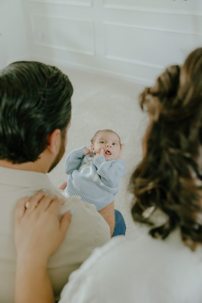 Parents interacting with their newborn baby during a relaxed in-home lifestyle photography session