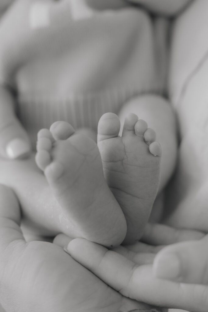 Close-up of a newborn baby's tiny feet during an in-home newborn photography session.
